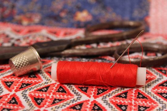 Red Thread and Thimble on Colorful Vintage Fabric