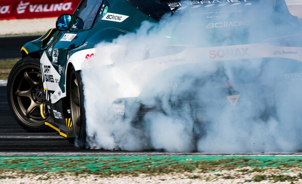 Drift car action detail, drifting on racetrack with large amount of smoke