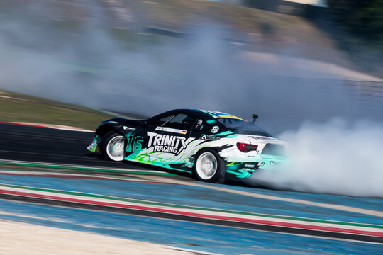 Drift car action, drifting on racetrack with large amount of smoke, blurred motion background