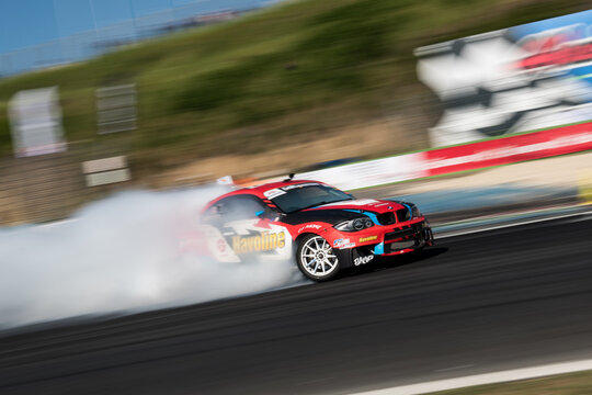 Drift car action, drifting on racetrack with large amount of smoke, blurred motion background, blurred background