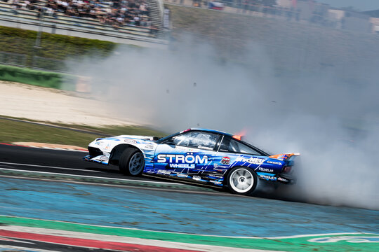 Drift car action, drifting on racetrack with large amount of smoke, blurred motion background

