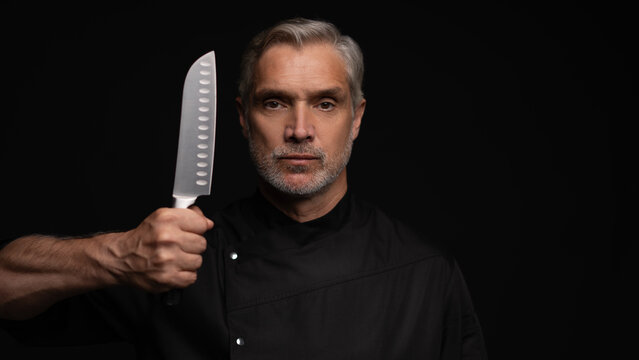 Portrait of positive 50s mature chef cook, black outfit