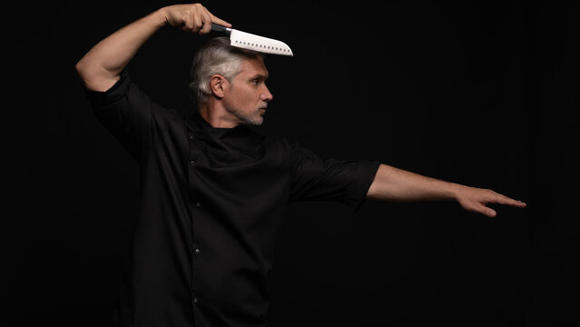Portrait of positive 50s mature chef cook, black outfit