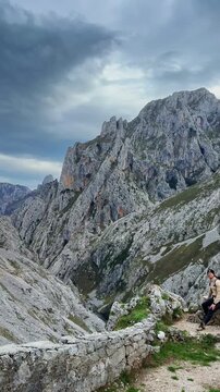 Traveler resting among rocky mountains in Cabrales Spain

Young man sitting peacefully among dramatic limestone cliffs while enjoying breathtaking mountain scenery and strong alpine wind.