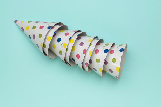 Colorful Polka Dot Party Hats Arranged in Spiral Pattern on Light Blue Background