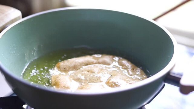 Indian bread or puri or pudi being fried in hot oil