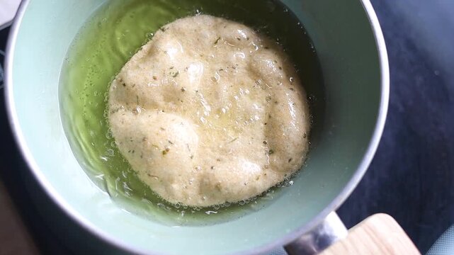 Indian bread or puri or pudi being fried in hot oil
