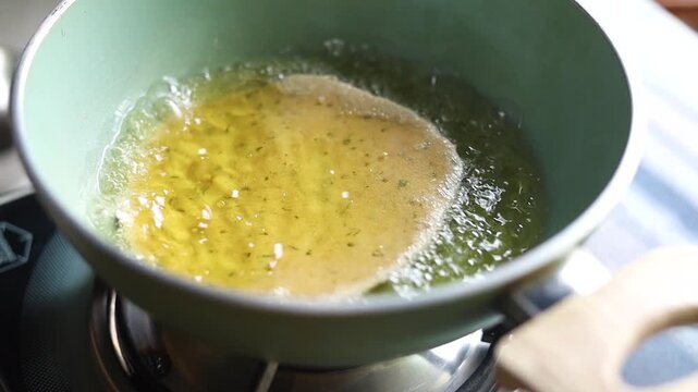 Indian bread or puri or pudi being fried in hot oil