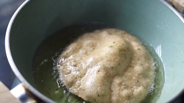 Indian bread or puri or pudi being fried in hot oil
