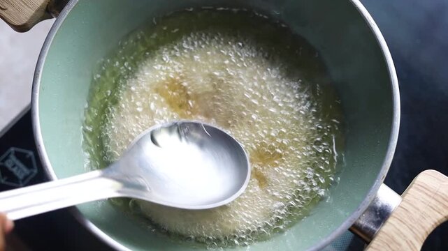 Indian bread or puri or pudi being fried in hot oil