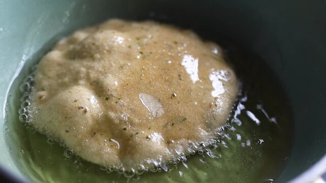 Indian bread or puri or pudi being fried in hot oil