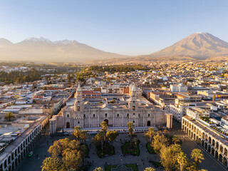 Obraz premium Aerial view of Plaza de Armas and the historic Arequipa Cathedral with the iconic peaks of El Misti and Chachani volcanoes on the horizon in Peru