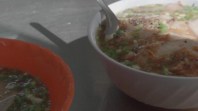 Close-up of a Bowl of Vietnamese Banh Canh with an Extra Side Dish of Pork at a Street Food Stall