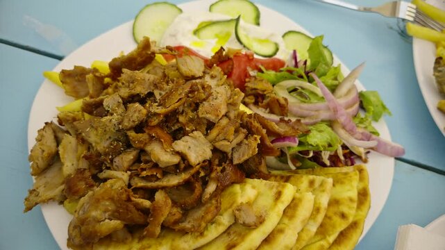 Greek Gyros Plate. Grilled Pork Meat Slices With Pita Bread French Fries Salad Tomatoes Onions Tzatziki Sauce. Mediterranean Street Food 