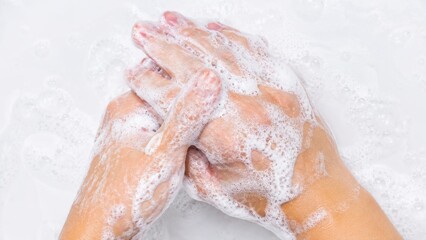 Fototapeta premium Person washing hands with thick white soap foam