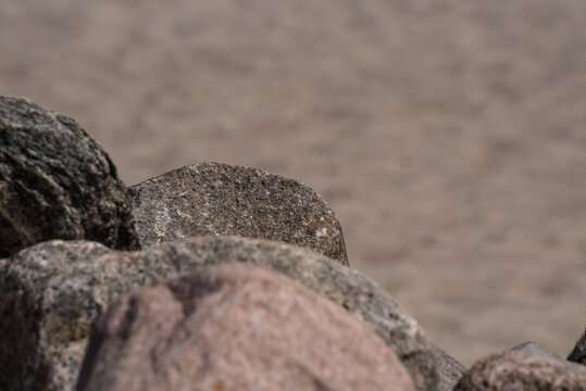 Detailed Coastal Rocks with Blurred Sandy Beach Background