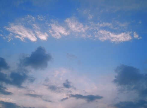 Soft stratocumulus formations illuminated by gentle low‑angle sunlight after rainfall 