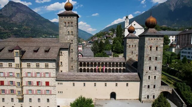 Stockalper castle Brig Switzerland drone view flying close between towers. Aerial cinematic FPV style proximity flight of baroque chateau palace architecture in Valais alps b-roll video