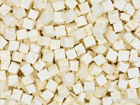 Cubes of Greek feta cheese. Delicious sheep's milk cheese in top view. Cheese background.
