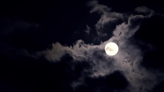 Full Moon Shining Through Dark Clouds at Night