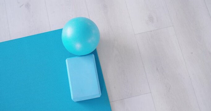 Slight camera nudge is making turquoise ball and foam-block roll and settle on mat for stability