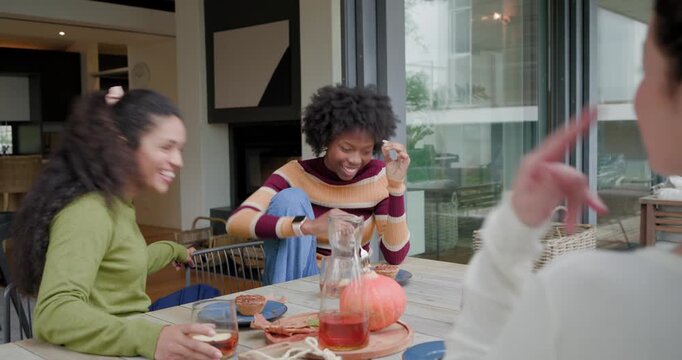 Female friends watching center woman starting story, gesturing, pouring pitcher tasting dessert