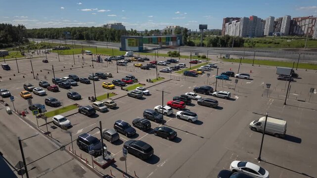 Elevated view of urban parking lot beside highway with apartments nearby