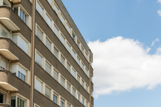 Brussels, Belgium. Modernist apartment building facade with repetitive windows and blue sky