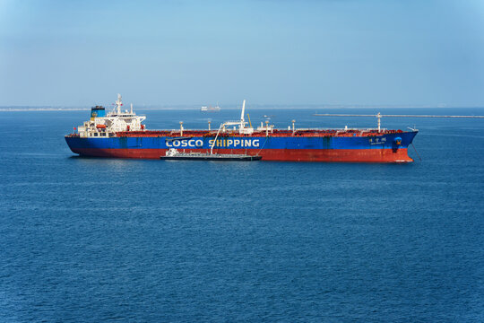 Long Beach, CA, USA - June 1, 2026: A cargo ship with the name Cosco Shipping on the side is anchored in the harbor area of Long Beach, California. 