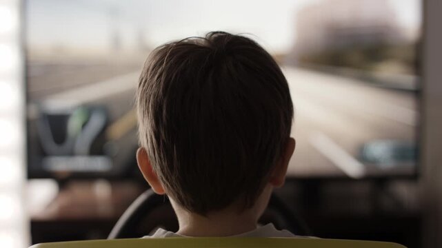 Boy Playing Racing Video Game in Game Console. Child Playing Computer Game in Headphones With Steering Wheel. Gamer With Headset Holding Steering Wheel Playing Video Game. Kid Gambling Addiction.