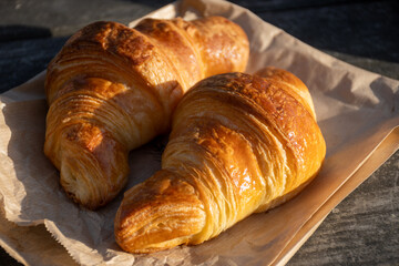 Fototapeta premium Freshly baked buttery croissants from a traditional French bakery in Brittany. Golden, flaky pastries with crispy layers, warm from the oven. Authentic French viennoiserie at its finest.