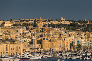 Fototapeta premium Charming historic streets and majestic architecture of Birgu (Vittoriosa), Malta. Admire the warm limestone facades, medieval defensive walls, and stunning waterfront marina views.
