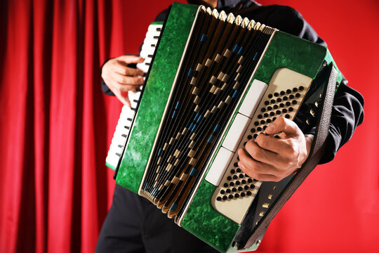 Man playing piano accordion on stage, closeup