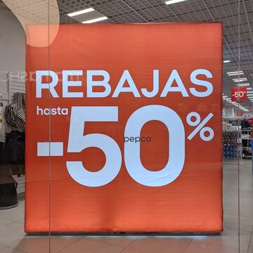 Vista de cerca de cartel con texto Rebajas hasta 50% en escaparate de tienda de ropa Pepco en Madrid, Espa&ntilde;a, 30 de junio de 2026