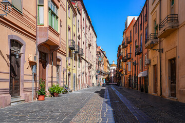 Fototapeta premium Street view of the cobbled Corso Vittorio Emanuele II in Bosa, Sardinia, Italy, with colorful historic architecture