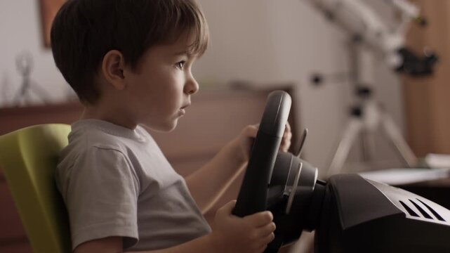 Boy Playing Racing Video Game in Game Console. Child Playing Computer Game in Headphones With Steering Wheel. Gamer With Headset Holding Steering Wheel Playing Video Game. Kid Gambling Addiction.