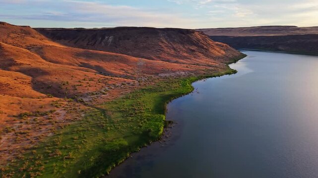 Aerial view captures the Snake River winding past golden bluffs across rural Idaho