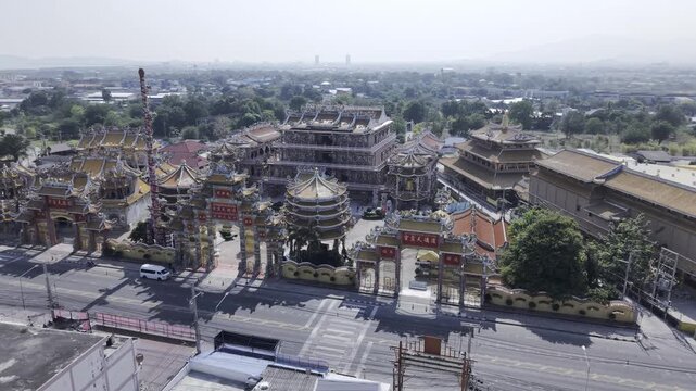 High angle drone shot of Na Jasaataichue Shrine, famous Chinese style architecture temple with golden roofs in Thailand.