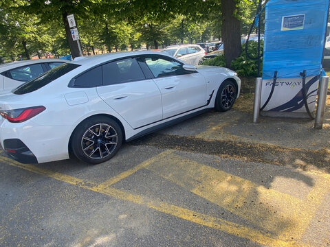 BMW i4 electric sedan charging at FASTWAY station, modern sustainable mobility in Cremona, Italy
