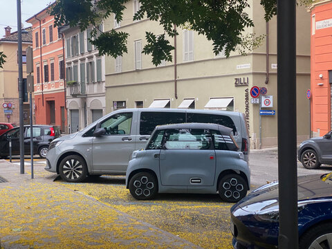 Citroen Ami electric microcar parked on Piazza Guglielmo Marconi, Cremona, Italy with traditional buildings