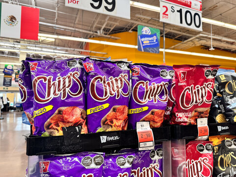 Bags of Chip's Flamin Hot potato chips by Barcel, Grupo Bimbo displayed on a supermarket shelf. Spicy savory snacks on retail store racks. Jalisco, Mexico July 11 2026.