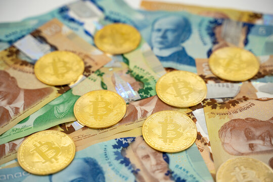 Close up of Bitcoin coins on Canadian dollar banknotes.
