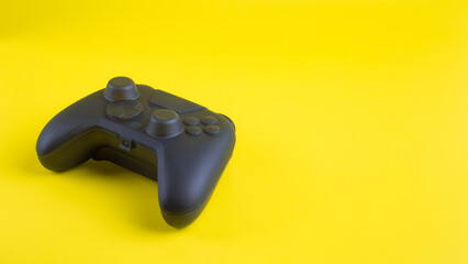 Angled blank black gamepad controller mockup on yellow background with negative space for gaming design.  © wibiwisnu