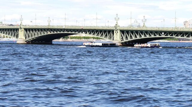 SAINT PETERSBURG, Russia- June 29, 2026: Troitsky Bridge over the Neva River. Sightseeing boats with tourists sail along the river. A hot sunny summer day.