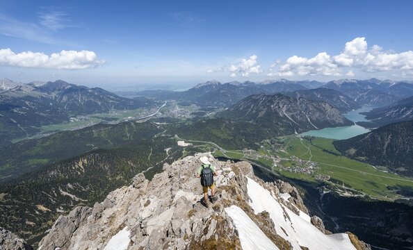 Hikers at the summit of Thaneller, view of mountains with Plansee and the town of Reutte, mountain landscape, Lechtal Alps, Tyrol, Austria