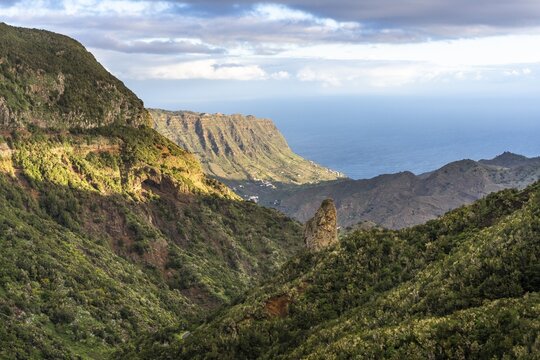 View of the valley of Hermigua and the sea. Mountains, hillsides with forest, palm trees, rocks. Good weather. La Gomera, Canary Islands, Spain