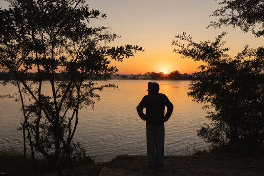 silhouette of boy and sunrise on the Zambezi River, Zimbabwe, Africa