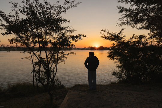 silhouette of boy and sunrise on the Zambezi River, Zimbabwe, Africa