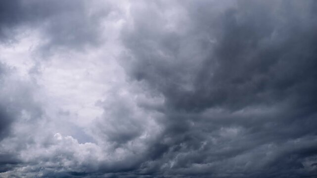 Ominous grey storm clouds move across the sky creating a dramatic and turbulent display. The heavy dark cloud cover suggests an impending storm with dynamic movement.