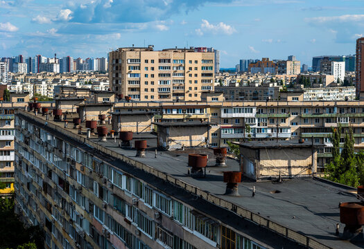 Dense urban landscape showcasing numerous soviet-era residential buildings and high-rise blocks, creating an expansive cityscape under a blue sky